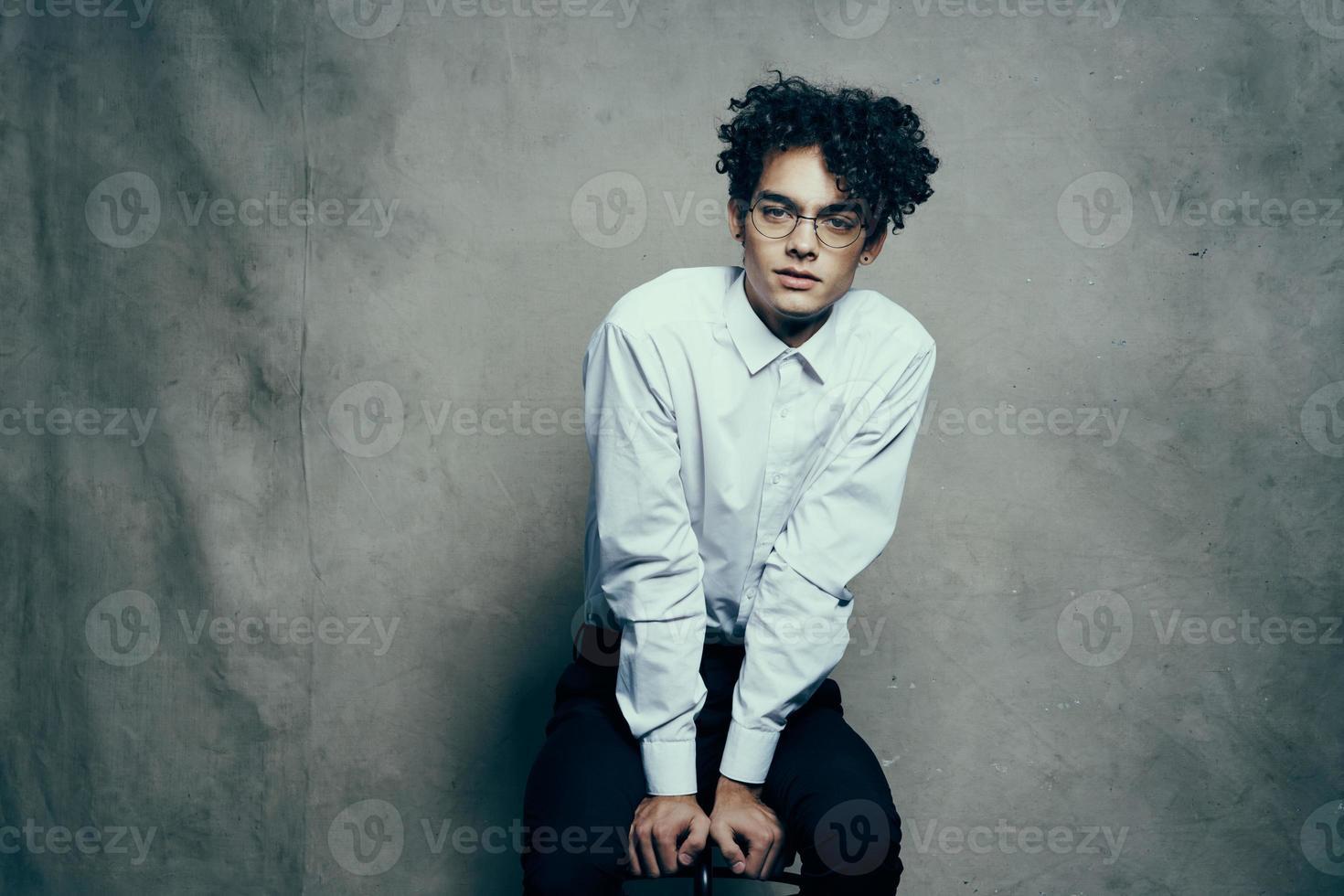 Rizado pelo joven hombre en camisa clásico traje fotografía estudio modelo en tela antecedentes foto