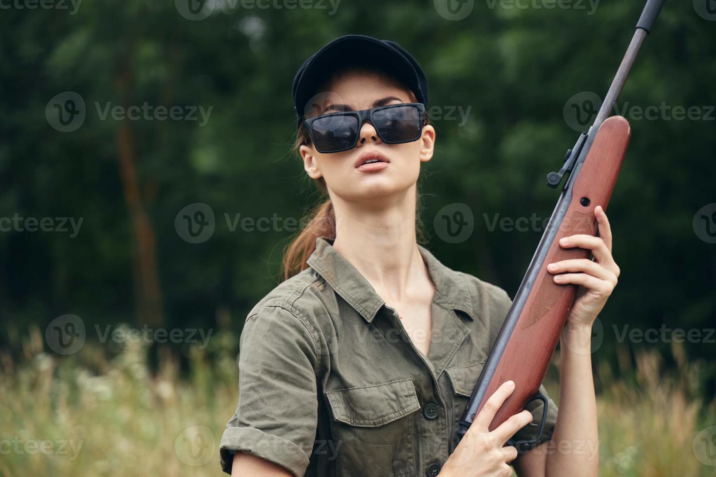 Military woman Shotgun hunting sunglasses green leaves photo