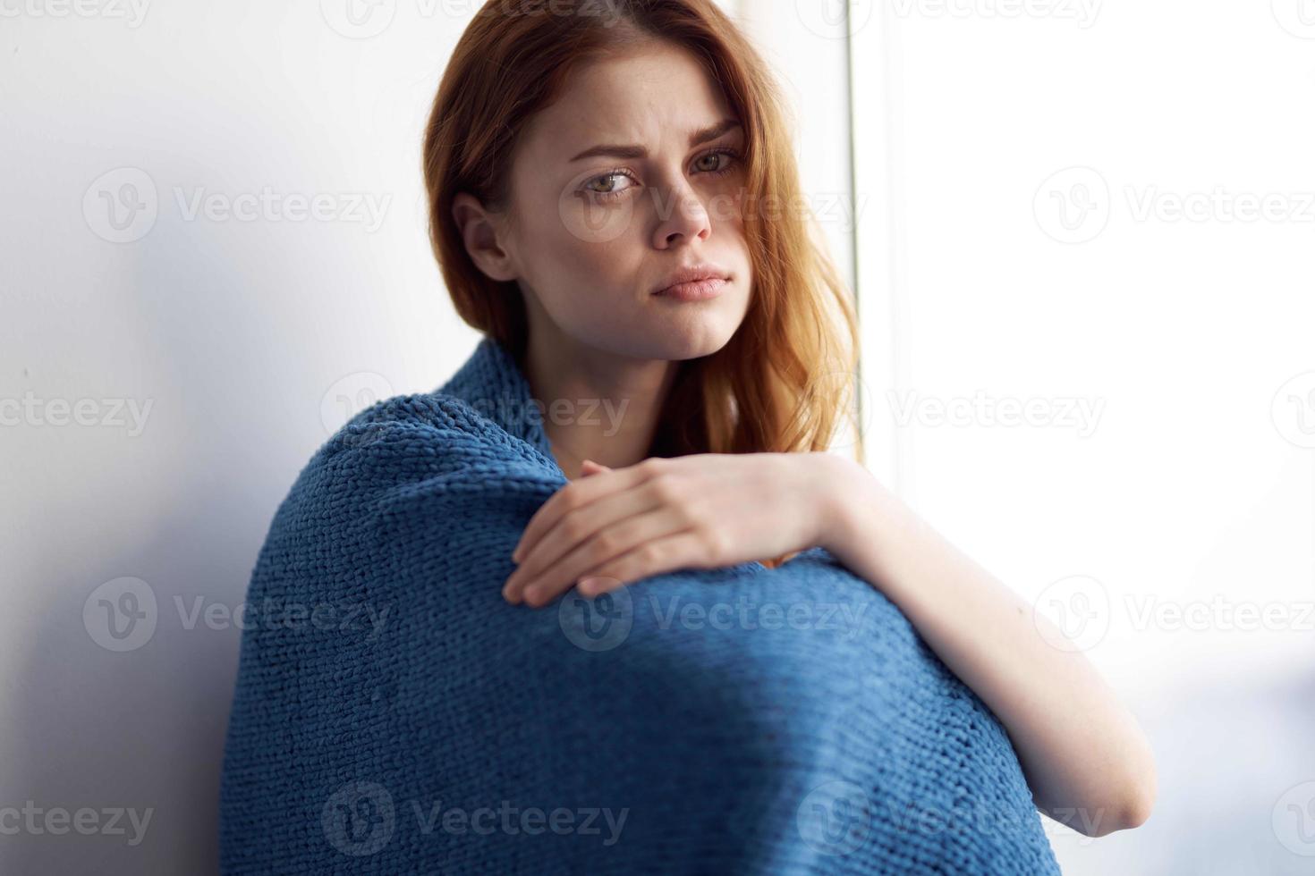 woman sitting near the window with a blue plaid smile at home photo