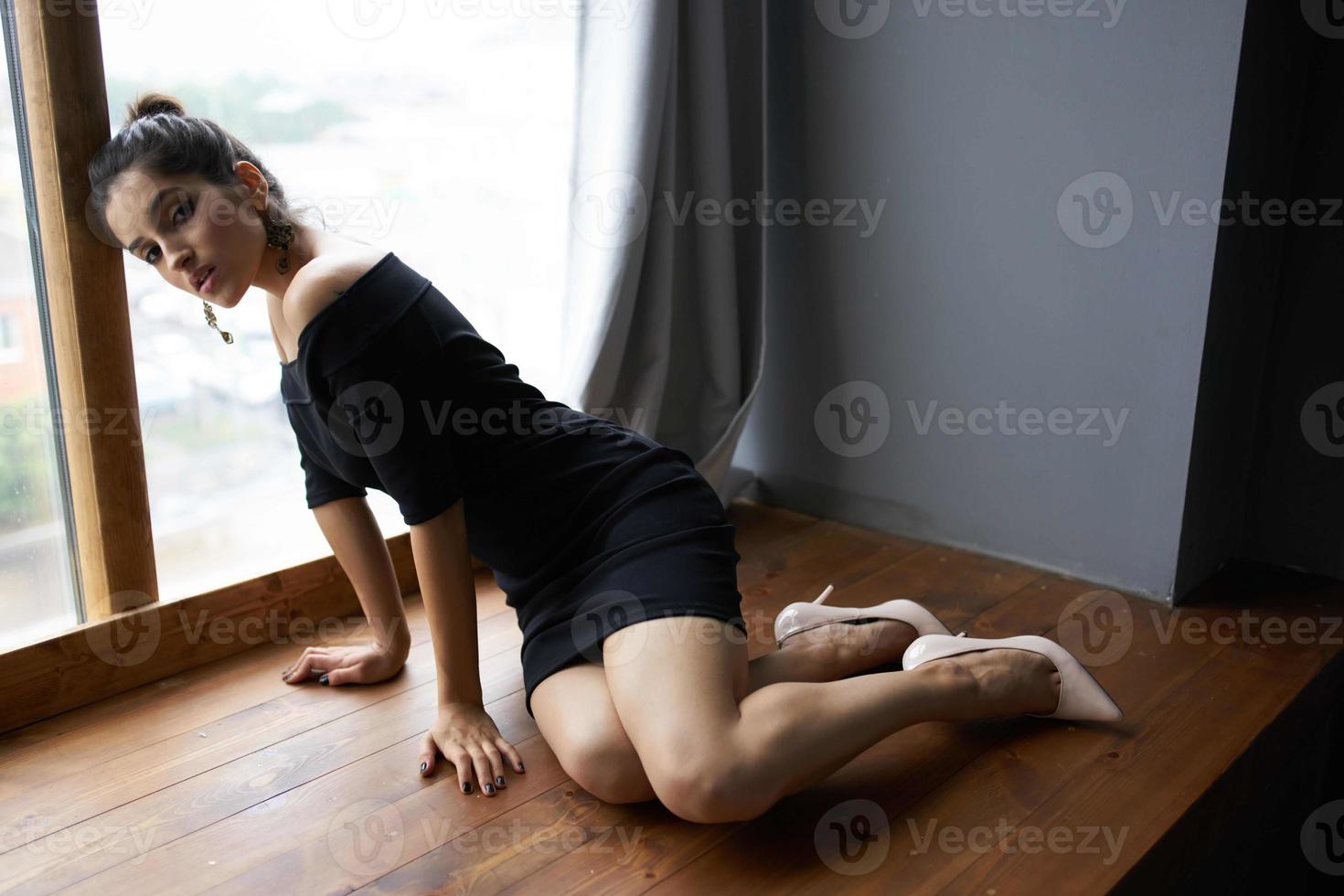 pretty woman in a black dress near the window posing elegant style photo