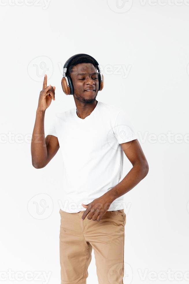 africano americano en auriculares en blanco camiseta escuchando a música entretenimiento foto