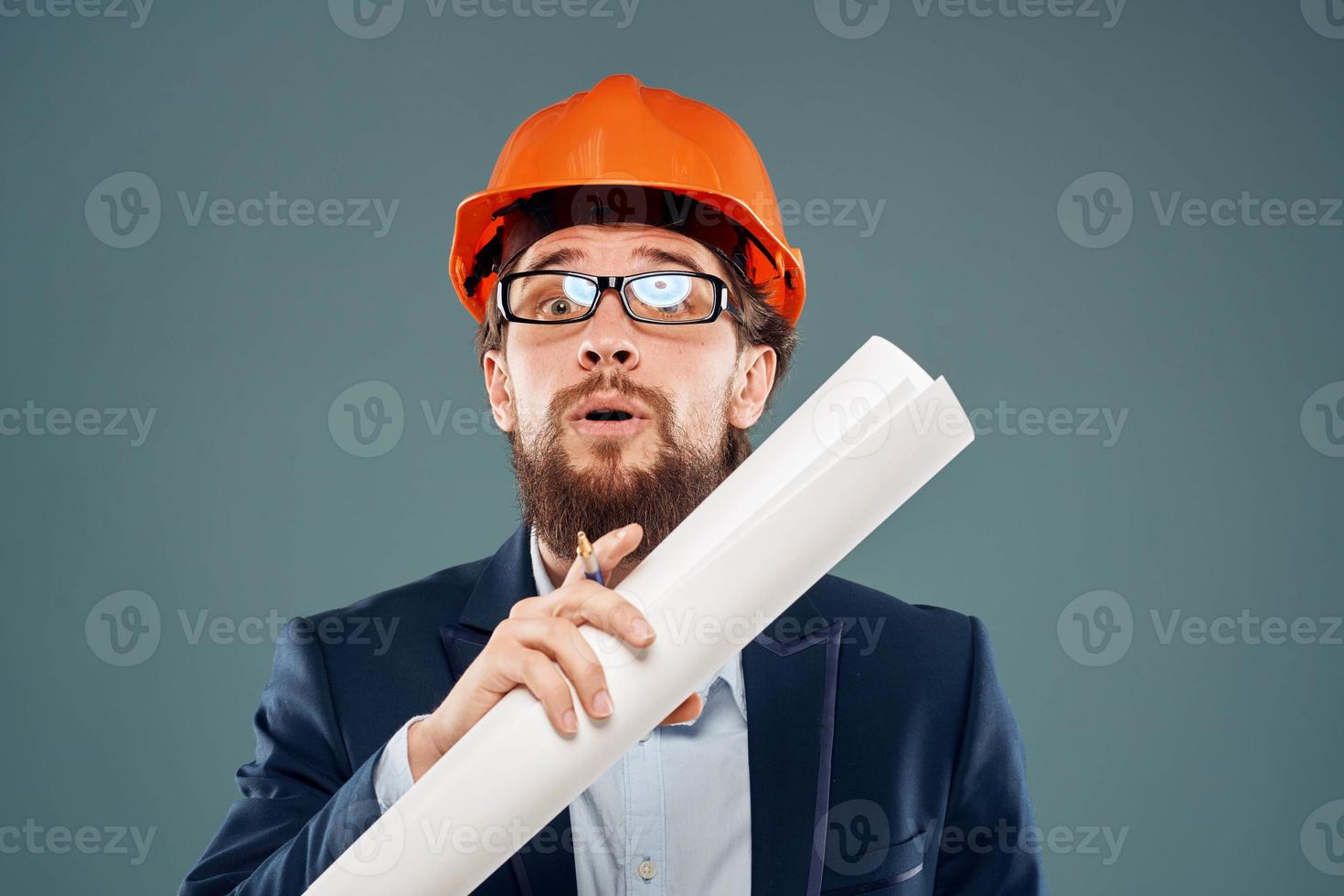 Cheerful man with blueprints in hands in orange helmet safety engineer cropped view photo