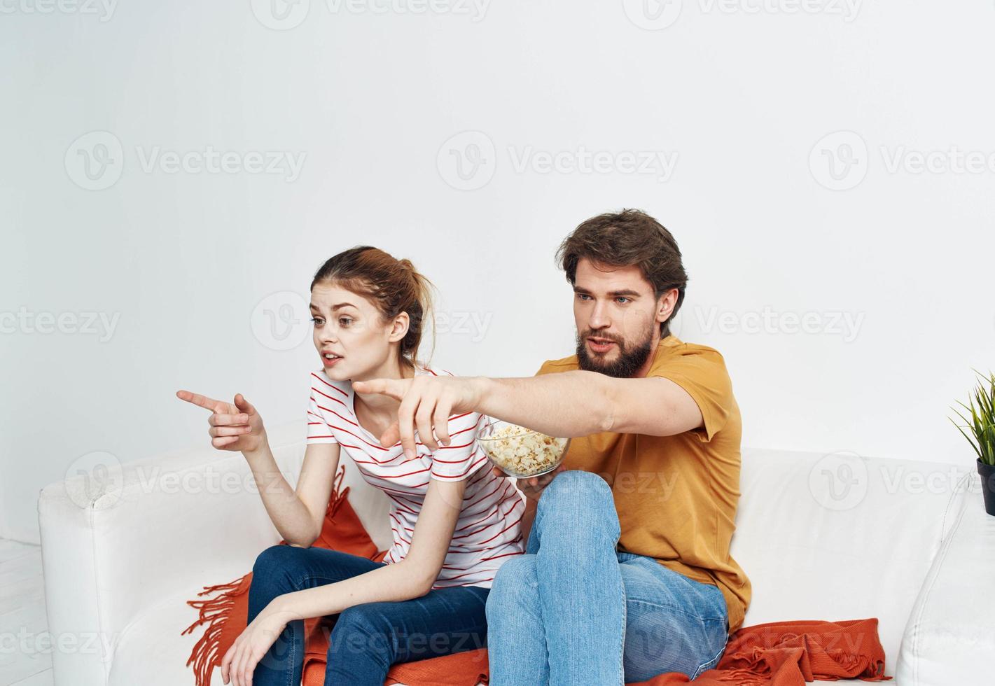 married couple on the couch popcorn watching tv indoors man woman photo