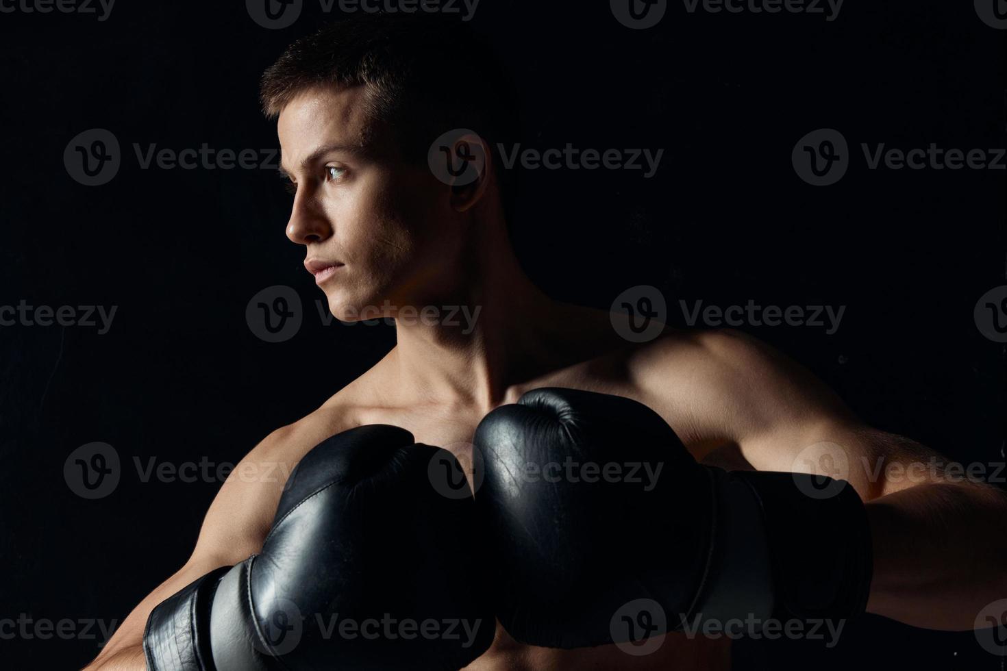 sport guy in boxing gloves close-up portrait black background photo