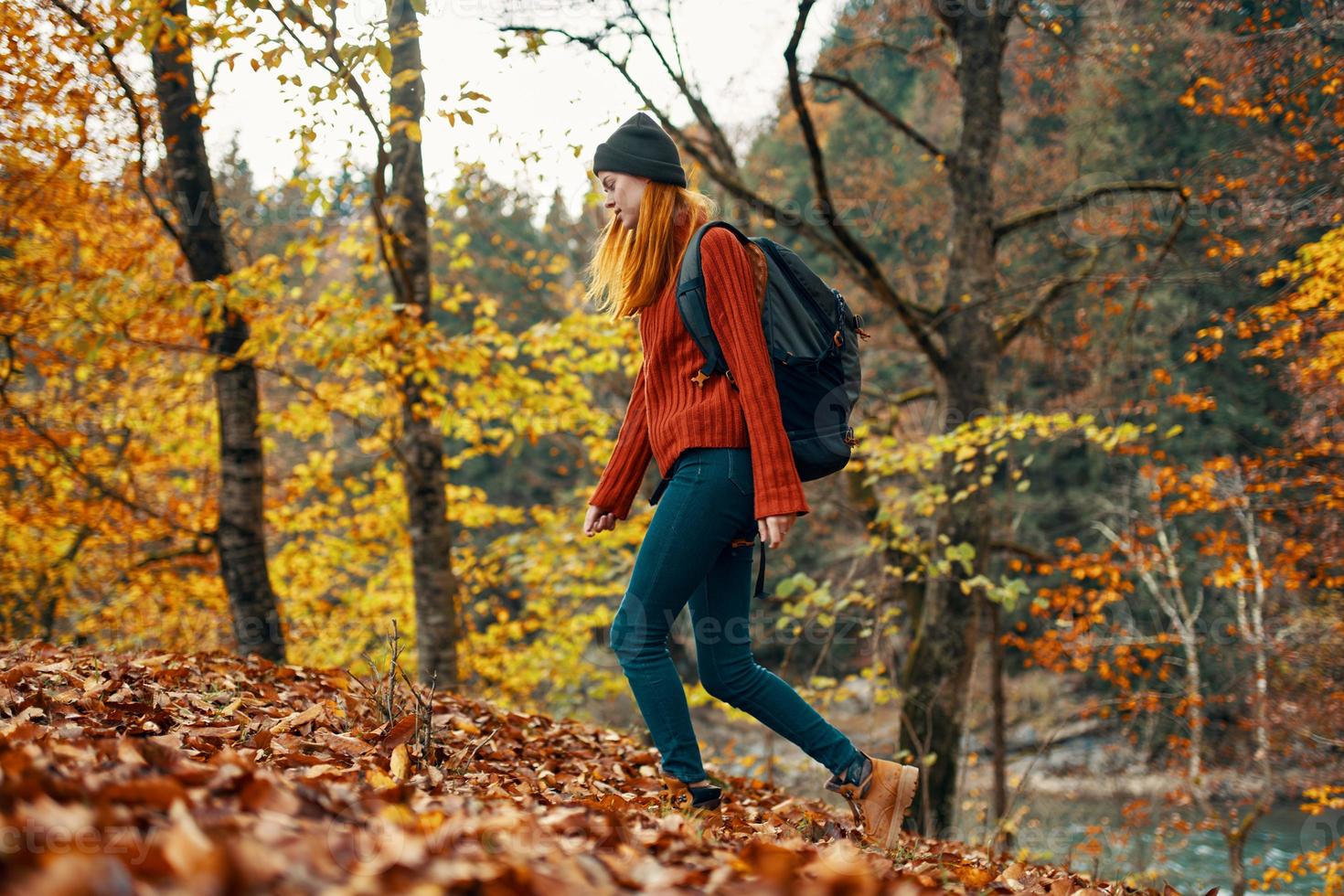 mujer viajero con mochila caminando en el parque en otoño en naturaleza lado ver foto