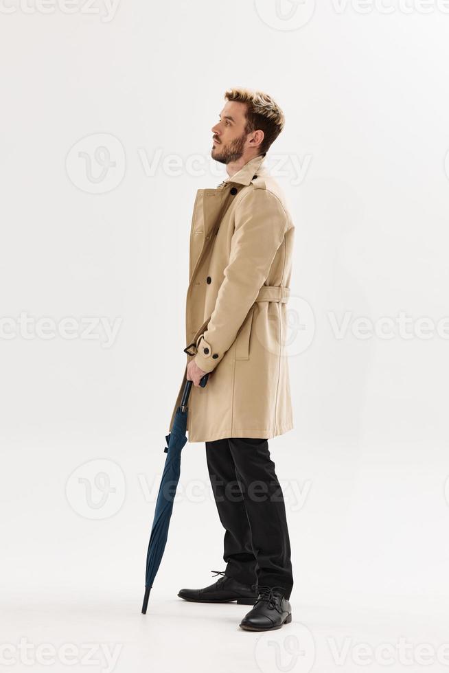 man in beige coat rain umbrella lifestyle posing photo