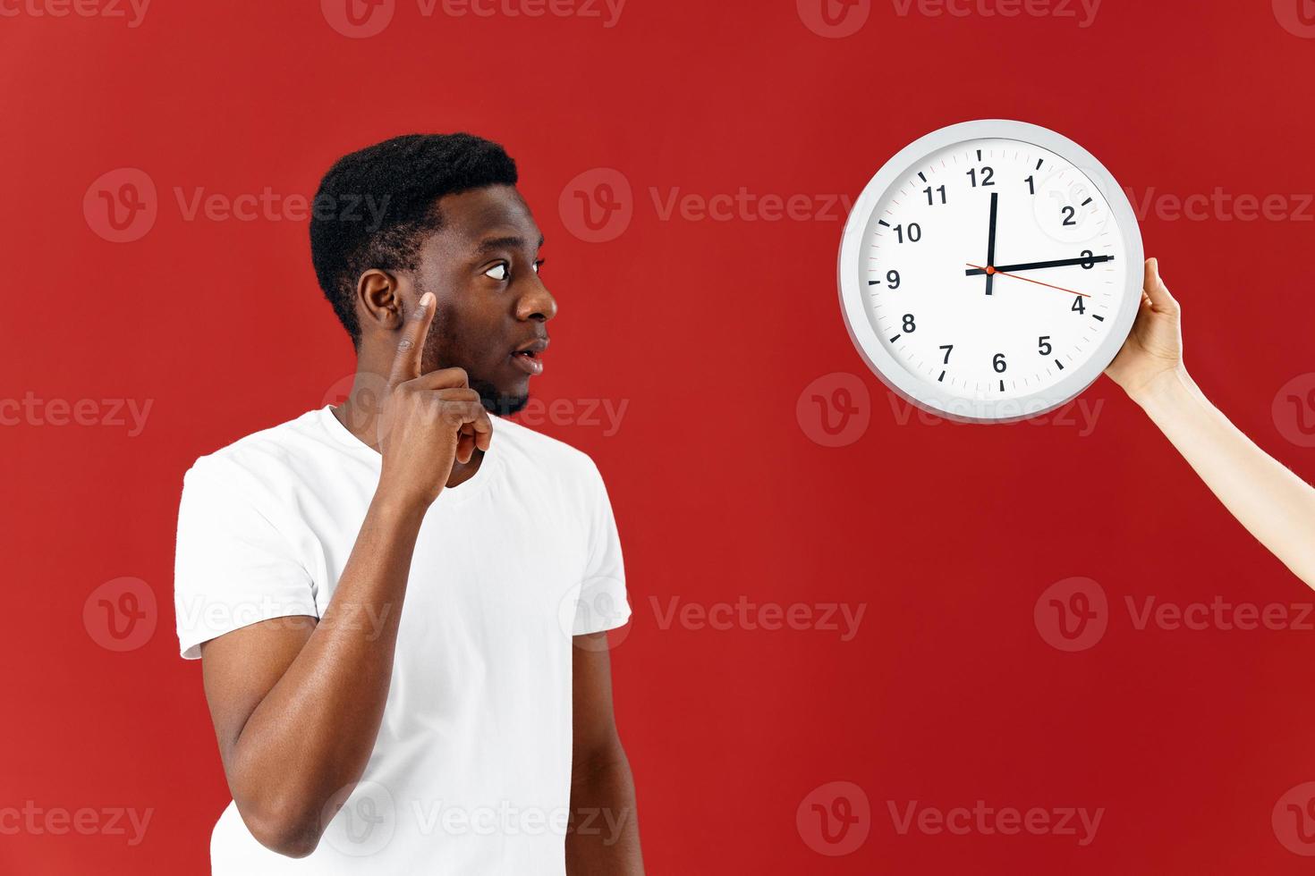 man holding hand near face clock emotions red background studio photo