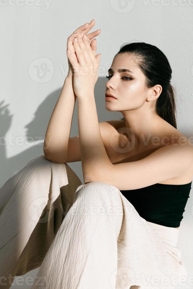 Strong woman in trousers sitting on the floor indoors photo