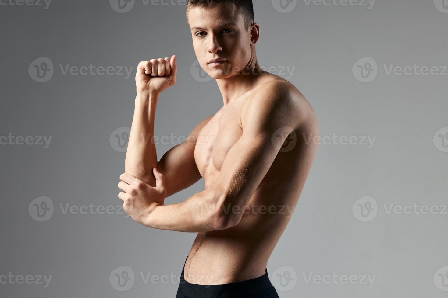 sexy guy athlete naked torso bodybuilder gray background Model Copy Space photo
