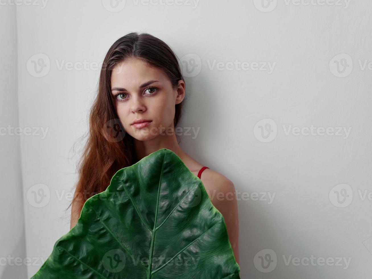 woman hides behind a green file sheet light background photo