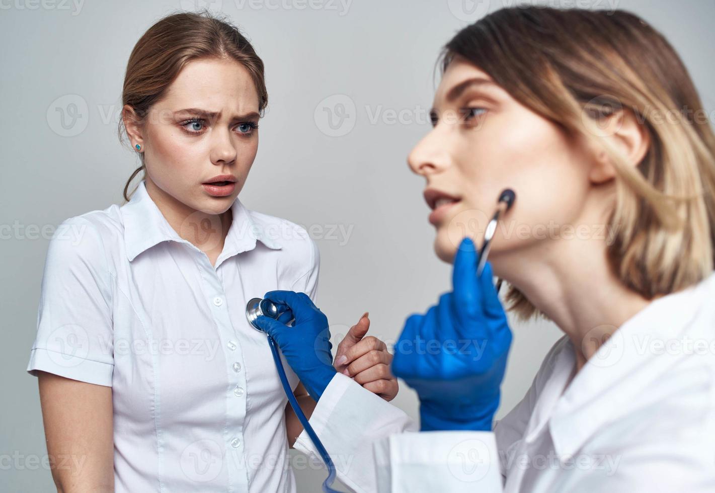 composición médico en un multitud y en azul guantes y un paciente en un blanco camiseta en un ligero antecedentes foto