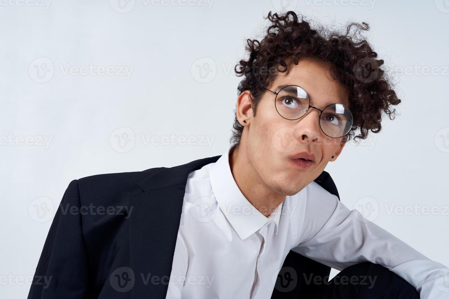 retrato de un pelo rizado chico en un camisa en un chaqueta y lentes foto