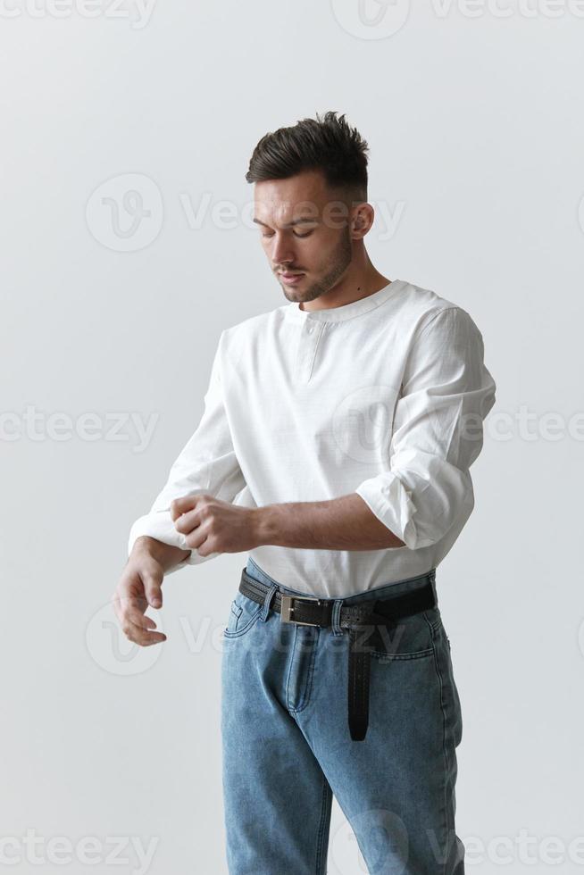 hermoso atractivo grave modelo hombre chico vestir lino camisa laminación arriba mangas posando aislado en blanco estudio antecedentes. Moda estilo nuevo colección rebaja anuncio concepto. Copiar espacio, bandera. modelo disparar foto