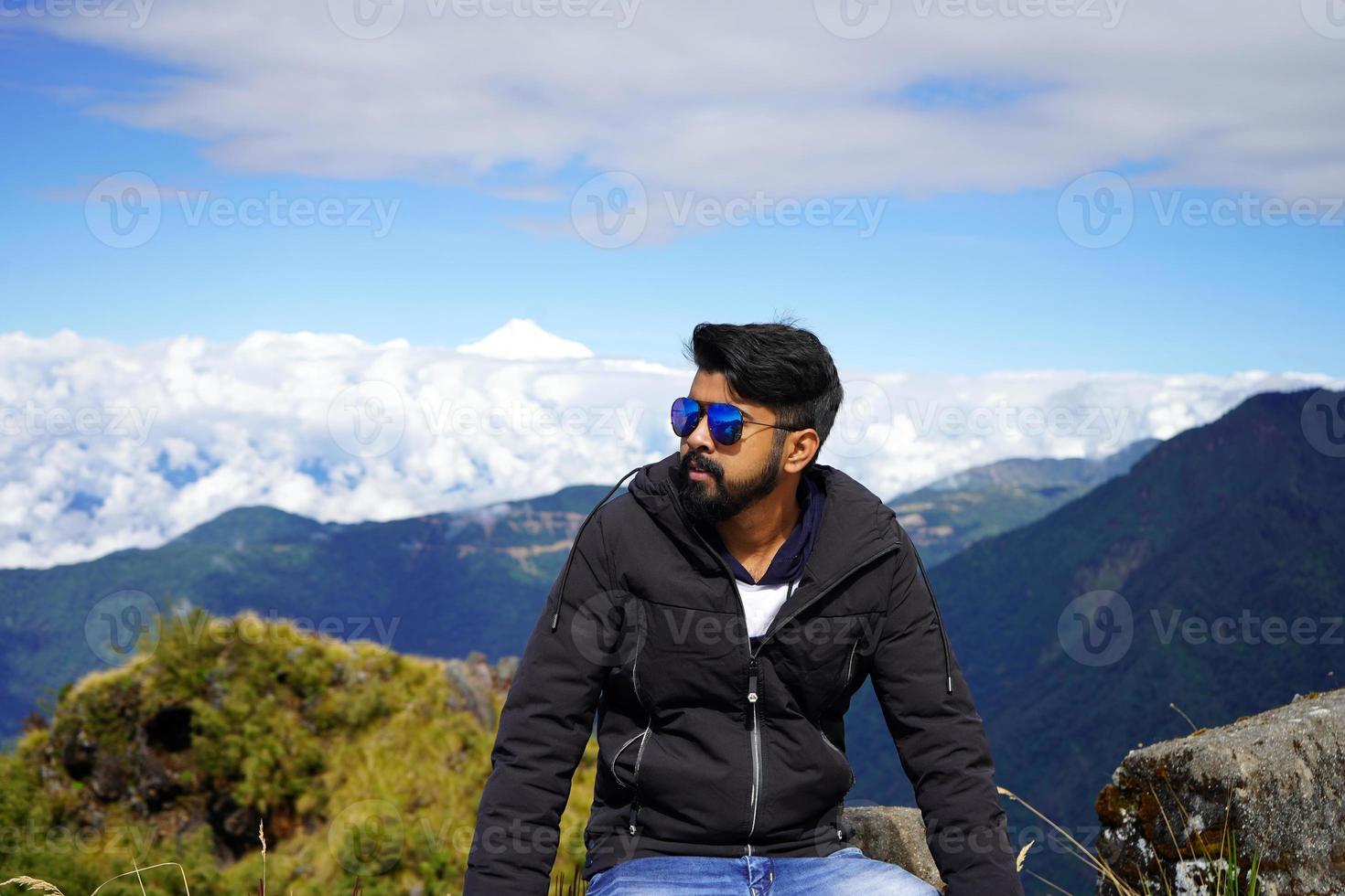 joven chico posando por sentado en seda ruta sikkim con Kanchenjunga en antecedentes foto