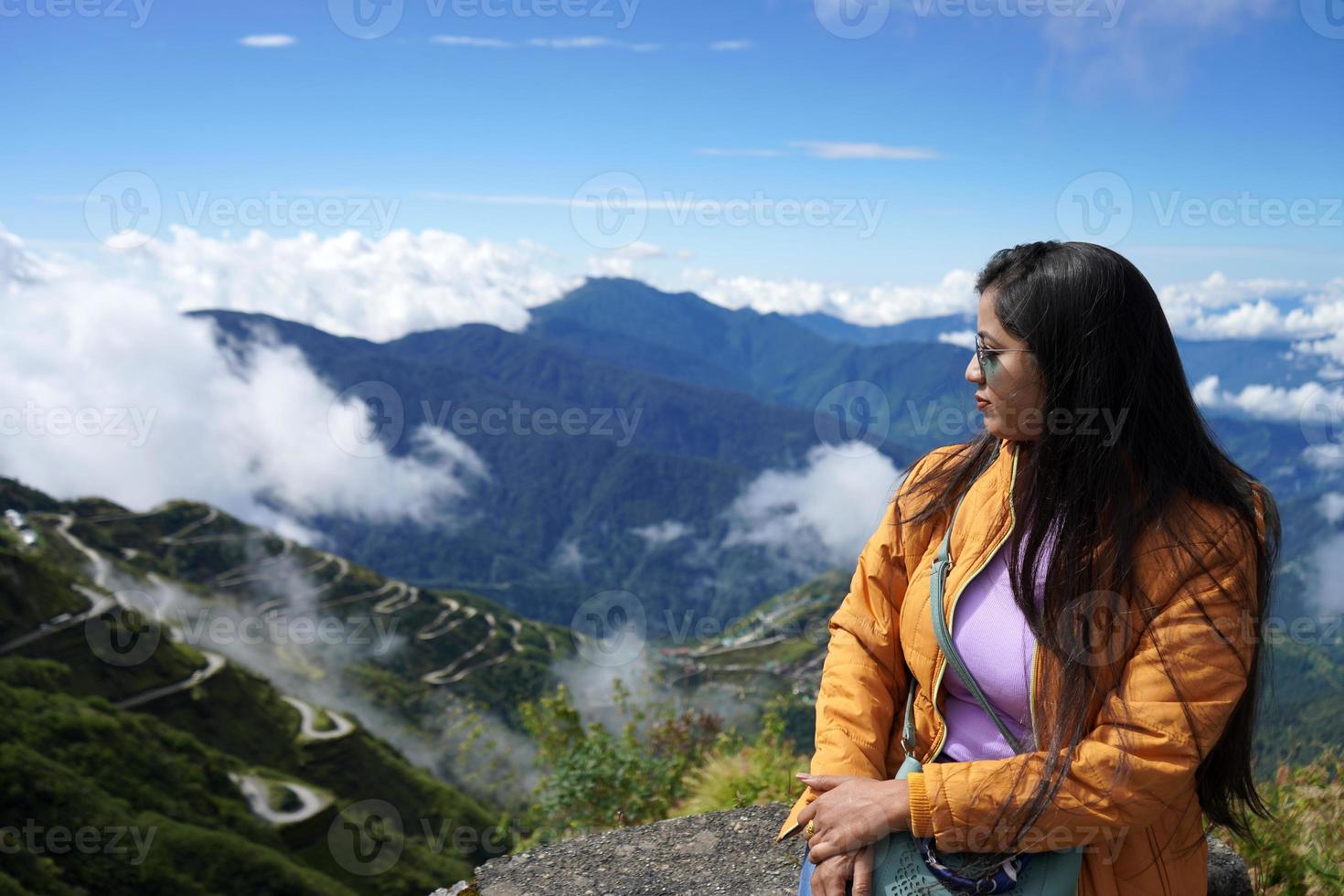 Young Lady Tourist Posing at Silk Route During her vacation with Zig Zag Road in Background photo