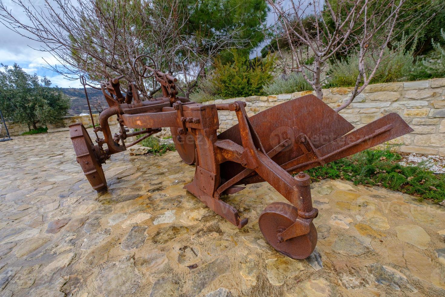 Rusted plough exhibited in a winery yard photo