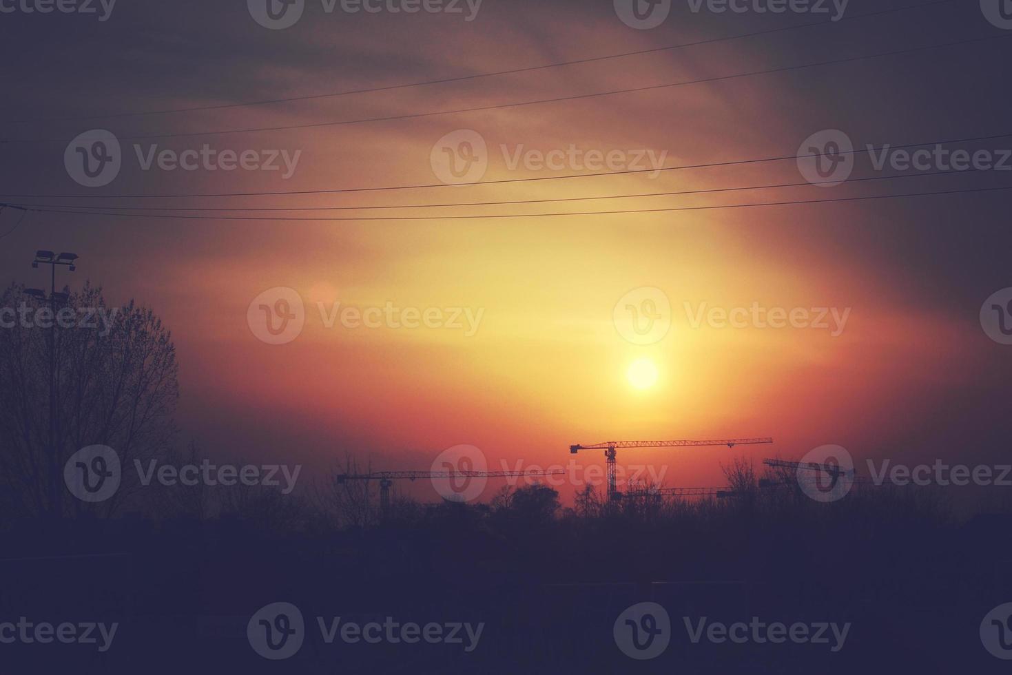 colorful sunset with red sky and trees and clouds photo