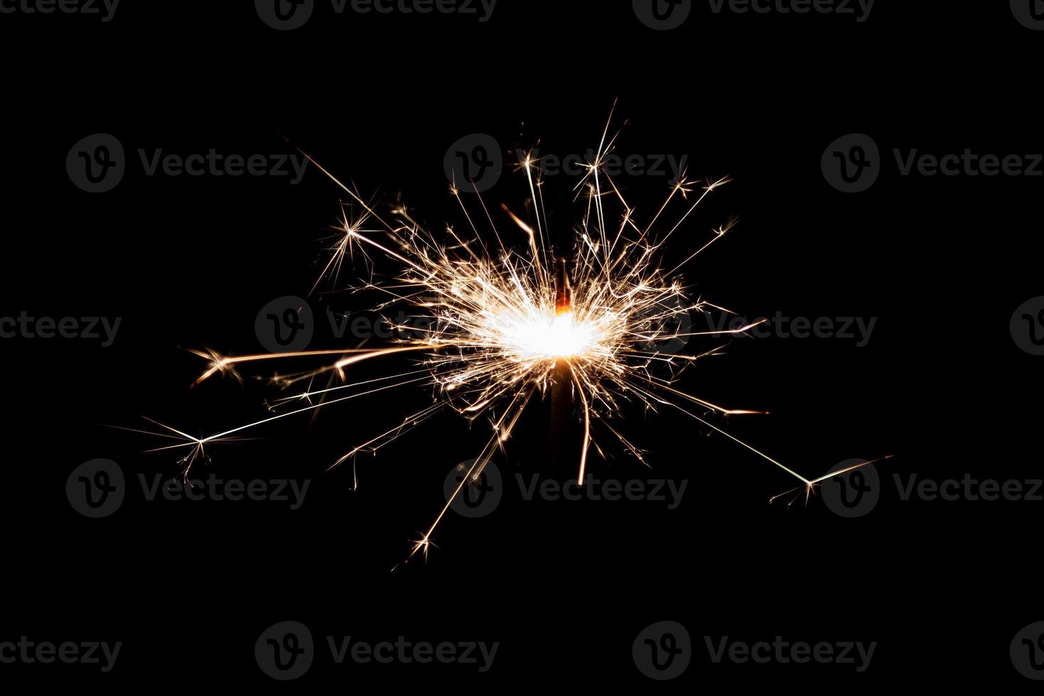 Burning sparkler isolated on black background. Fireworks theme. Light effect and texture. photo