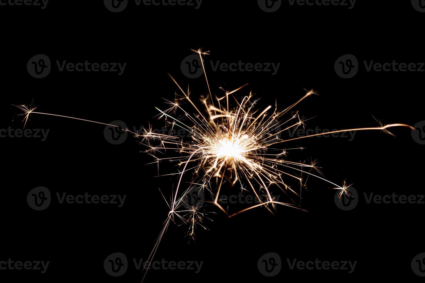Burning sparkler isolated on black background. Fireworks theme. Light effect and texture. photo