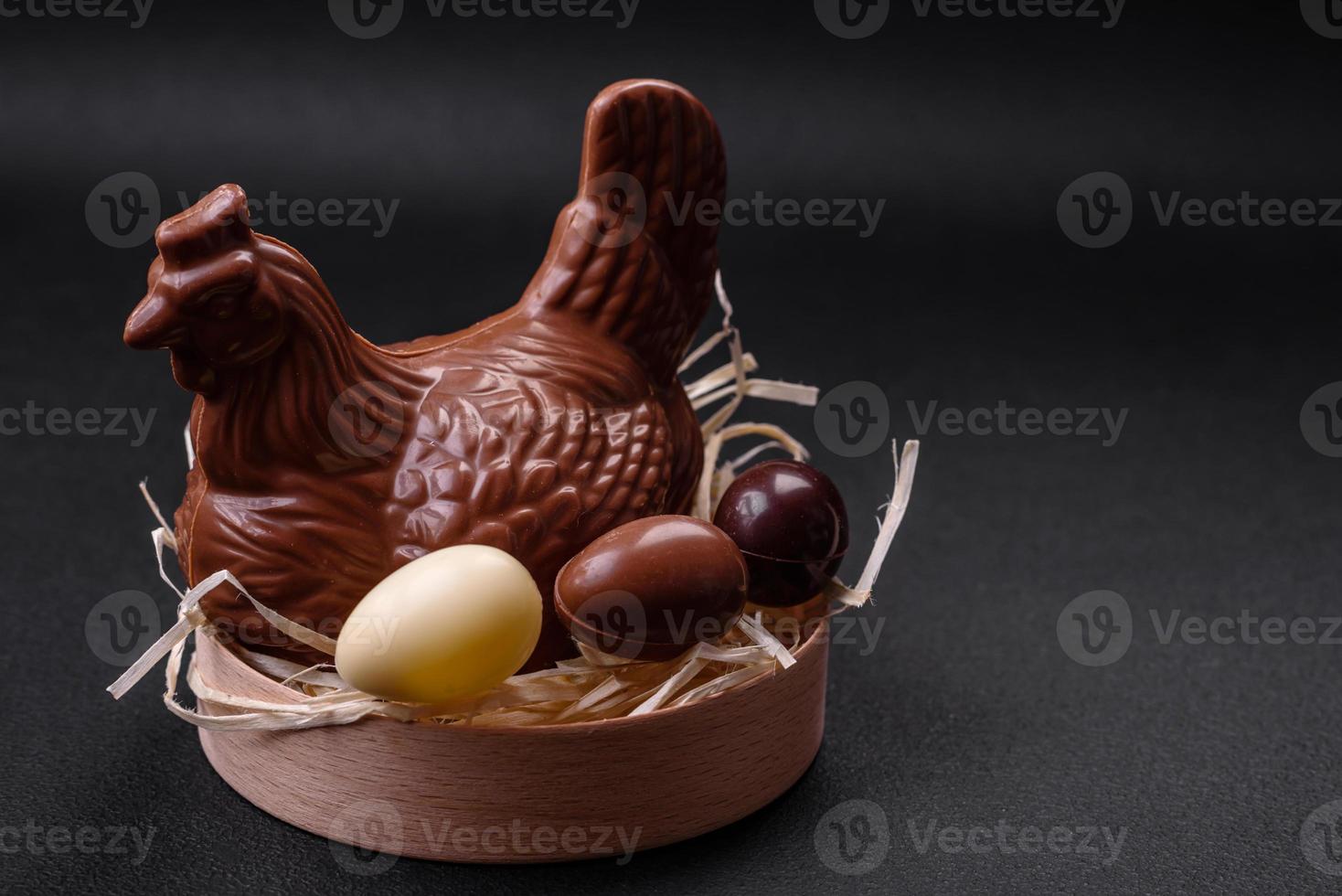 Chocolate Easter hen and eggs in a nest with straw photo