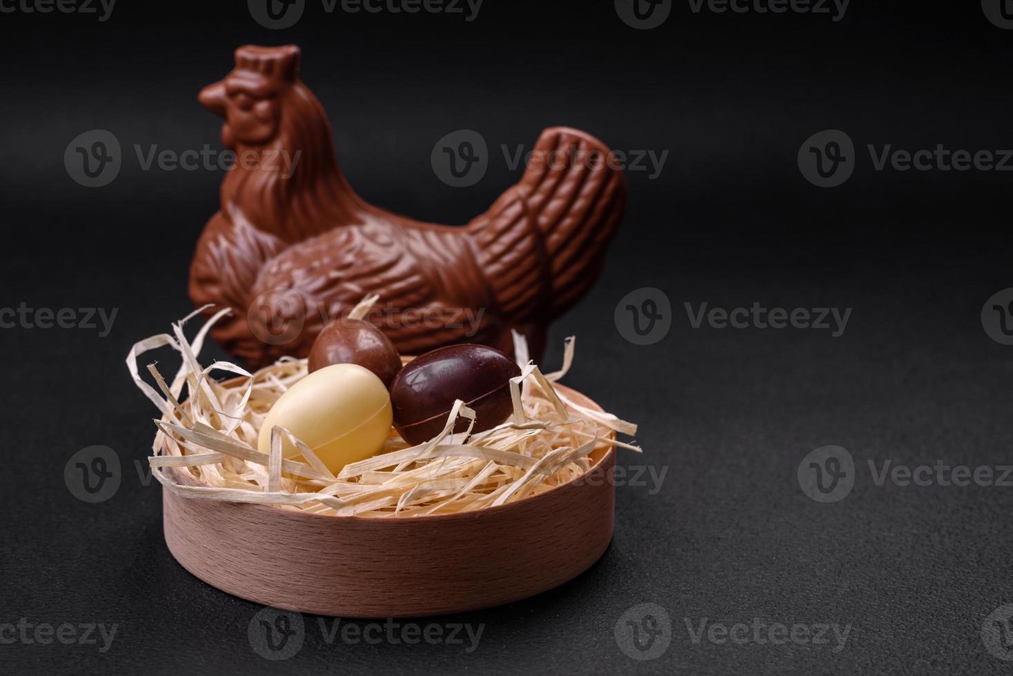 Chocolate Easter hen and eggs in a nest with straw photo