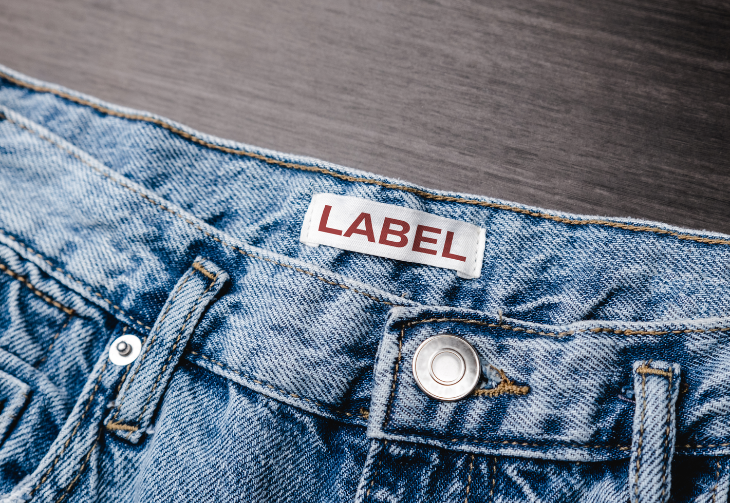 Blank clothing label on denim jeans texture. Label with empty space for text psd