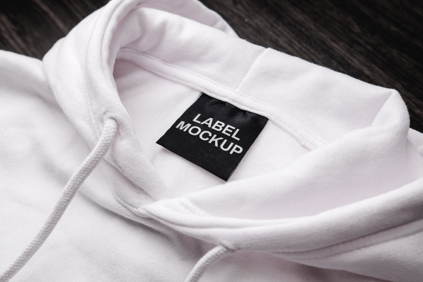 Blank clothing label on the texture of a white sweater hoodie. Label with  empty space for text 22396952 PSD