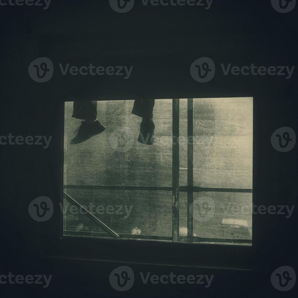 background with legs dangling against the backdrop of the window photo