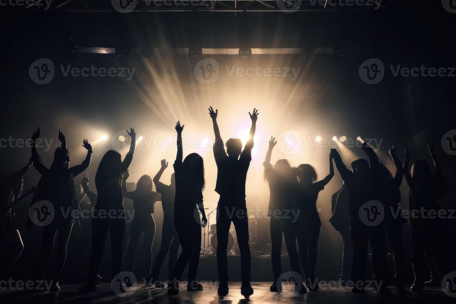 Black silhouette of a huge crowd of cheering people in front of a rock stage with soft bokeh lights created with technology. photo