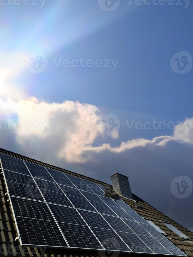 Solar panels producing clean energy on a roof of a residential house photo