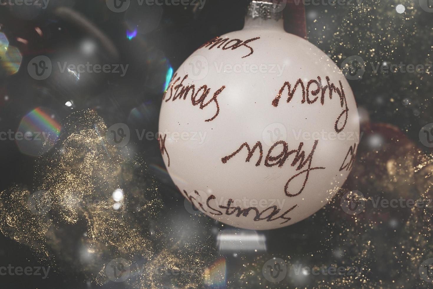 white bauble with red inscription merry christmas on a festive background photo