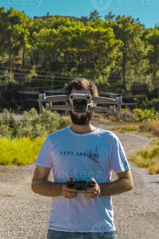 Auburn Haired White T-Shirt Drone Pilot With Drone On His Face photo