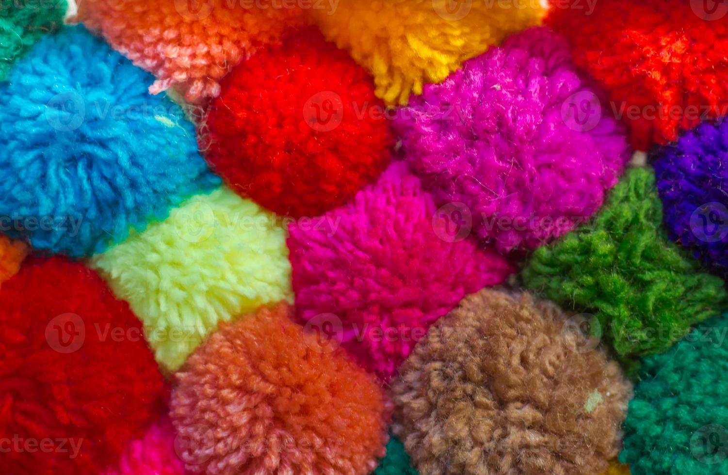 textured background of assorted and multicolored wool pom poms photo