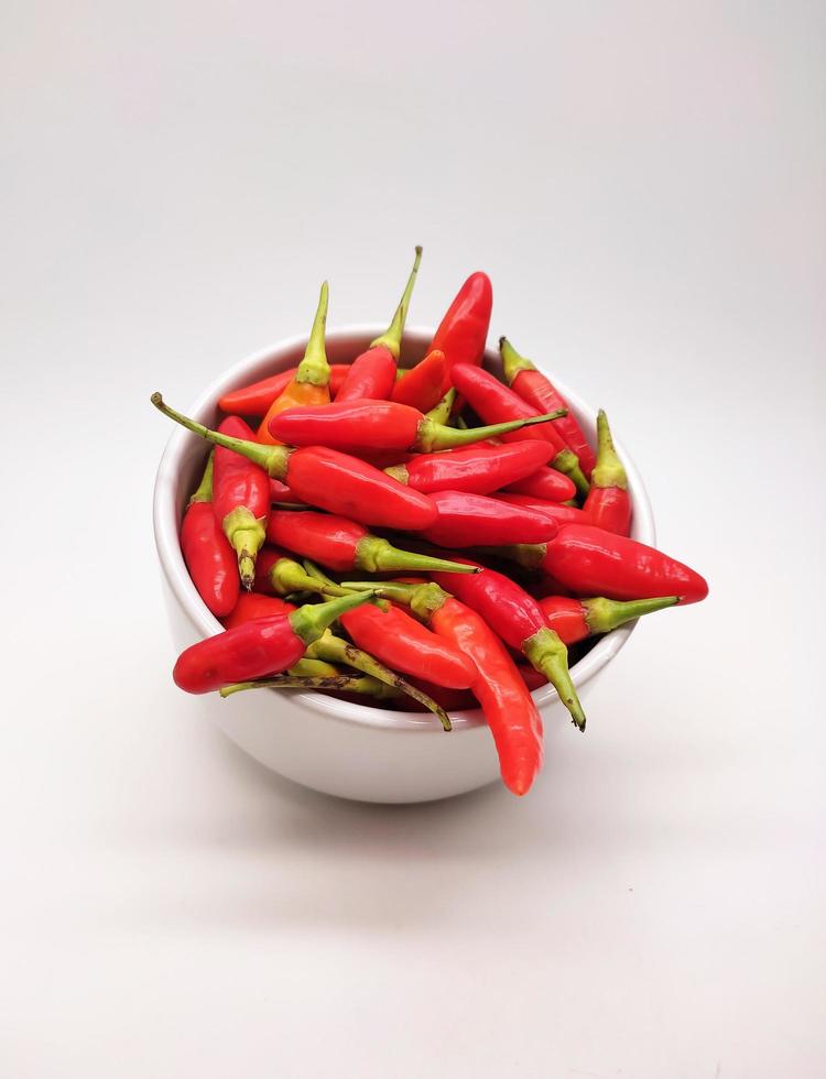 Chili peppers or Cayenne pepper or Cabe rawit in a bowl isolated on white background. photo