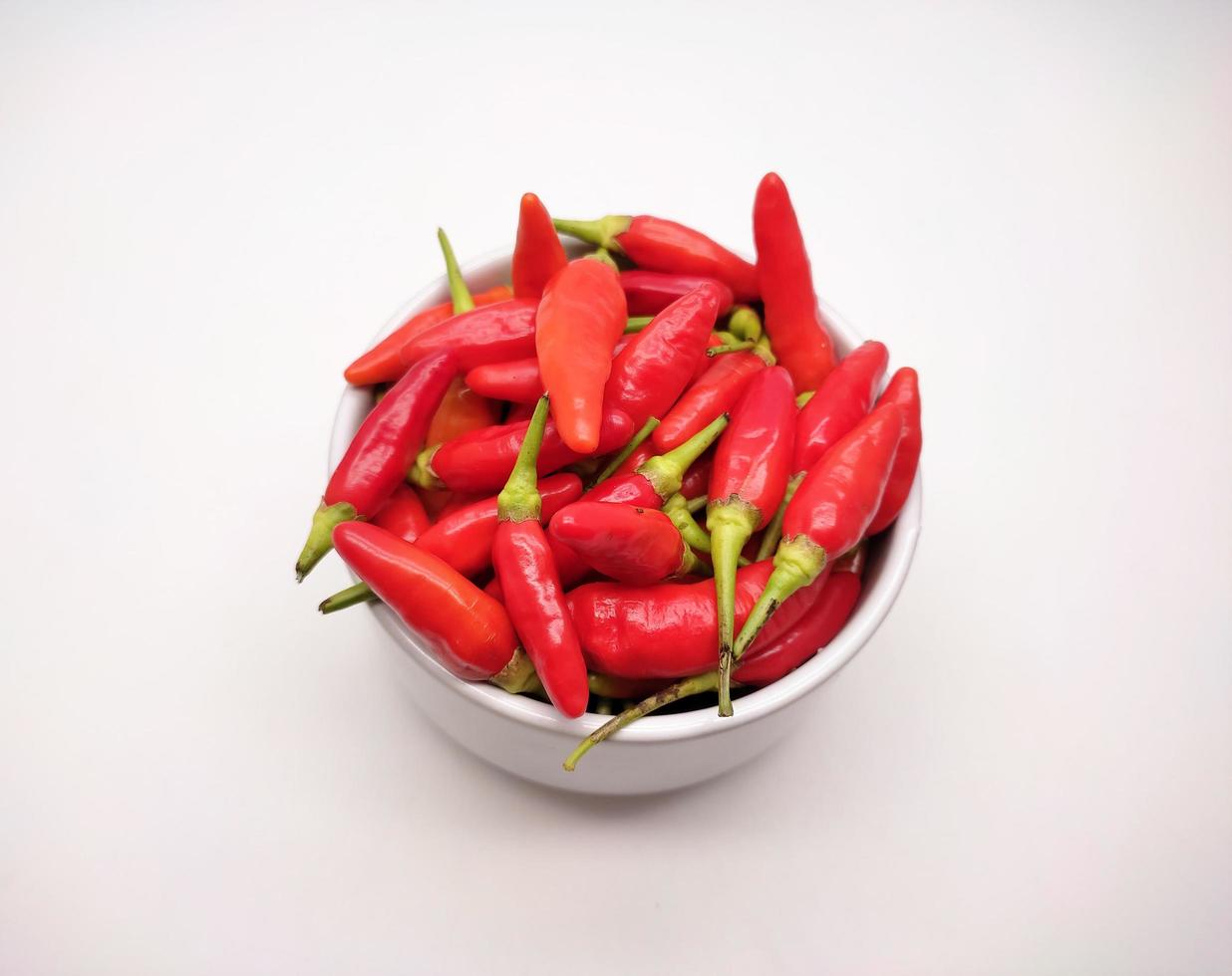 Chili peppers or Cayenne pepper or Cabe rawit in a bowl isolated on white background. photo