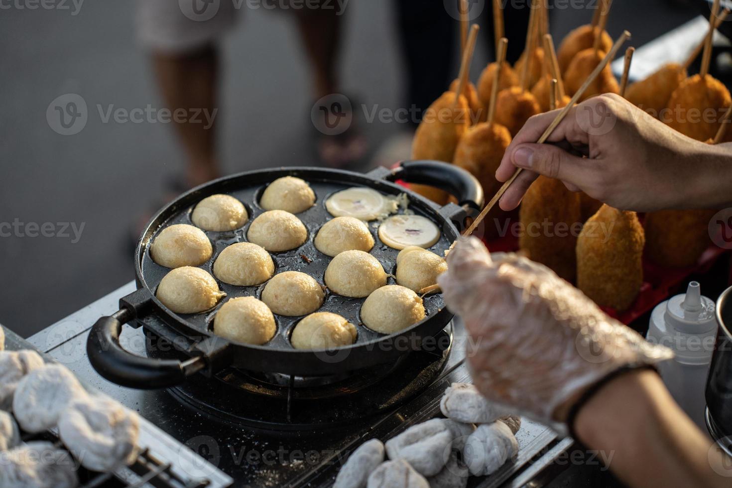 Food vendors making takoyaki, a delicious street food snack at the jogokariyan ramadhan market photo