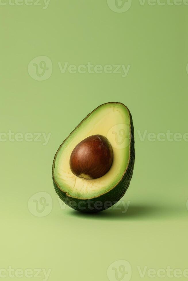 Studio shoot of half an avocado with pit on light green solid background. Ai genearated. photo