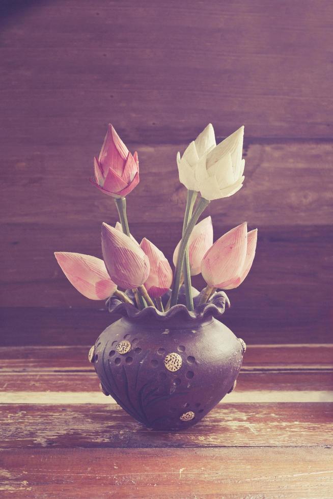 still life lotus in old cray jar on wood photo