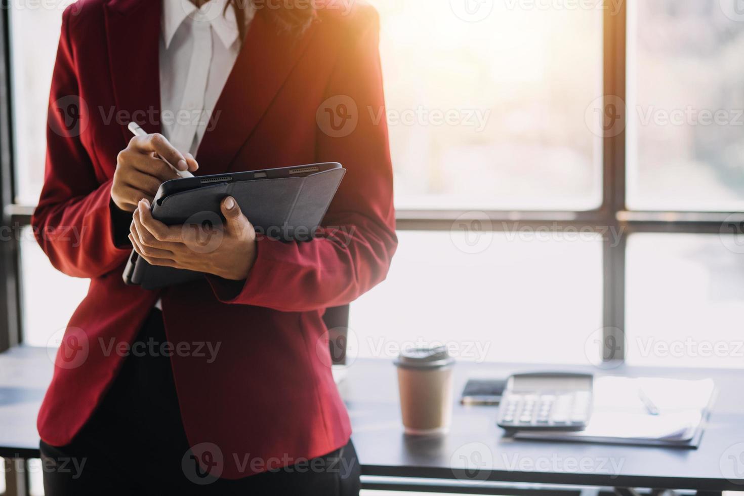 Asian Business woman using calculator and laptop for doing math finance on an office desk, tax, report, accounting, statistics, and analytical research concept photo