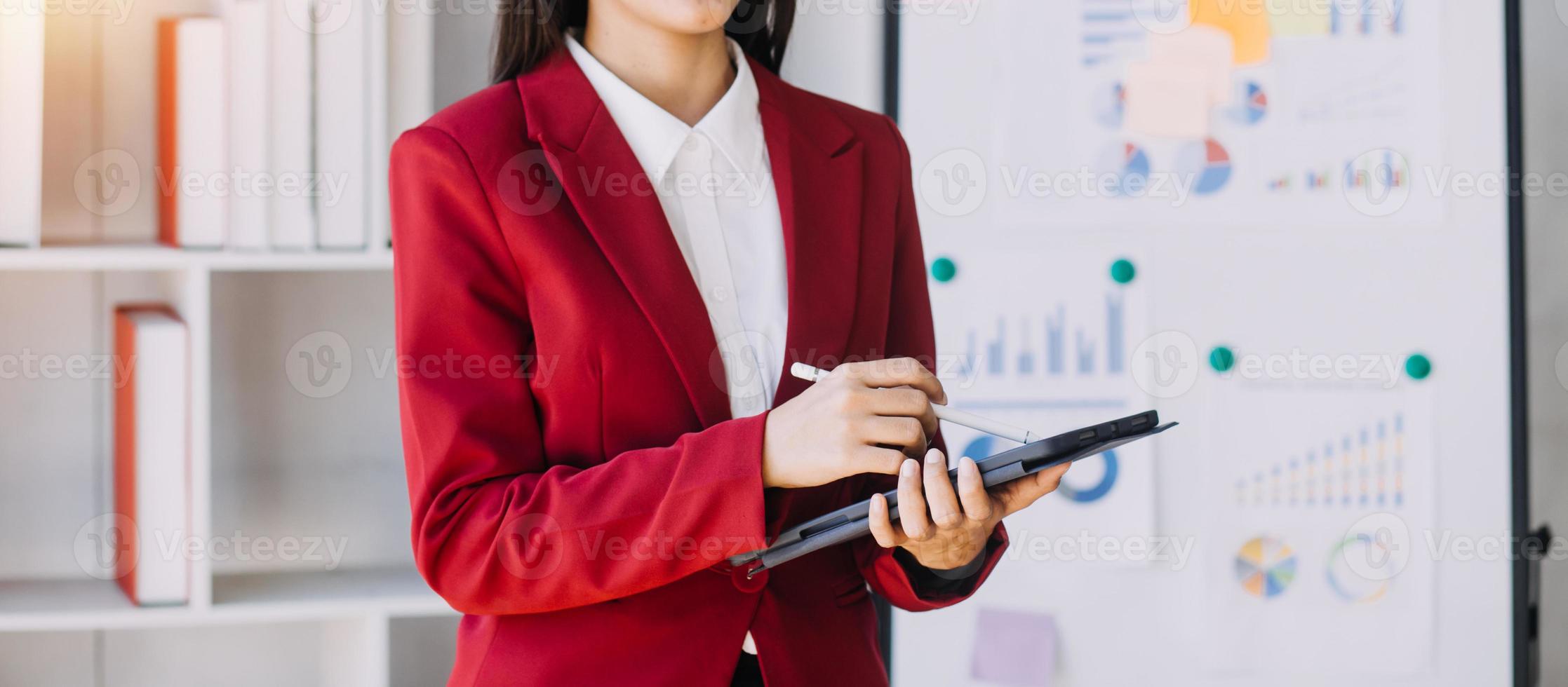 Asian Business woman using calculator and laptop for doing math finance on an office desk, tax, report, accounting, statistics, and analytical research concept photo
