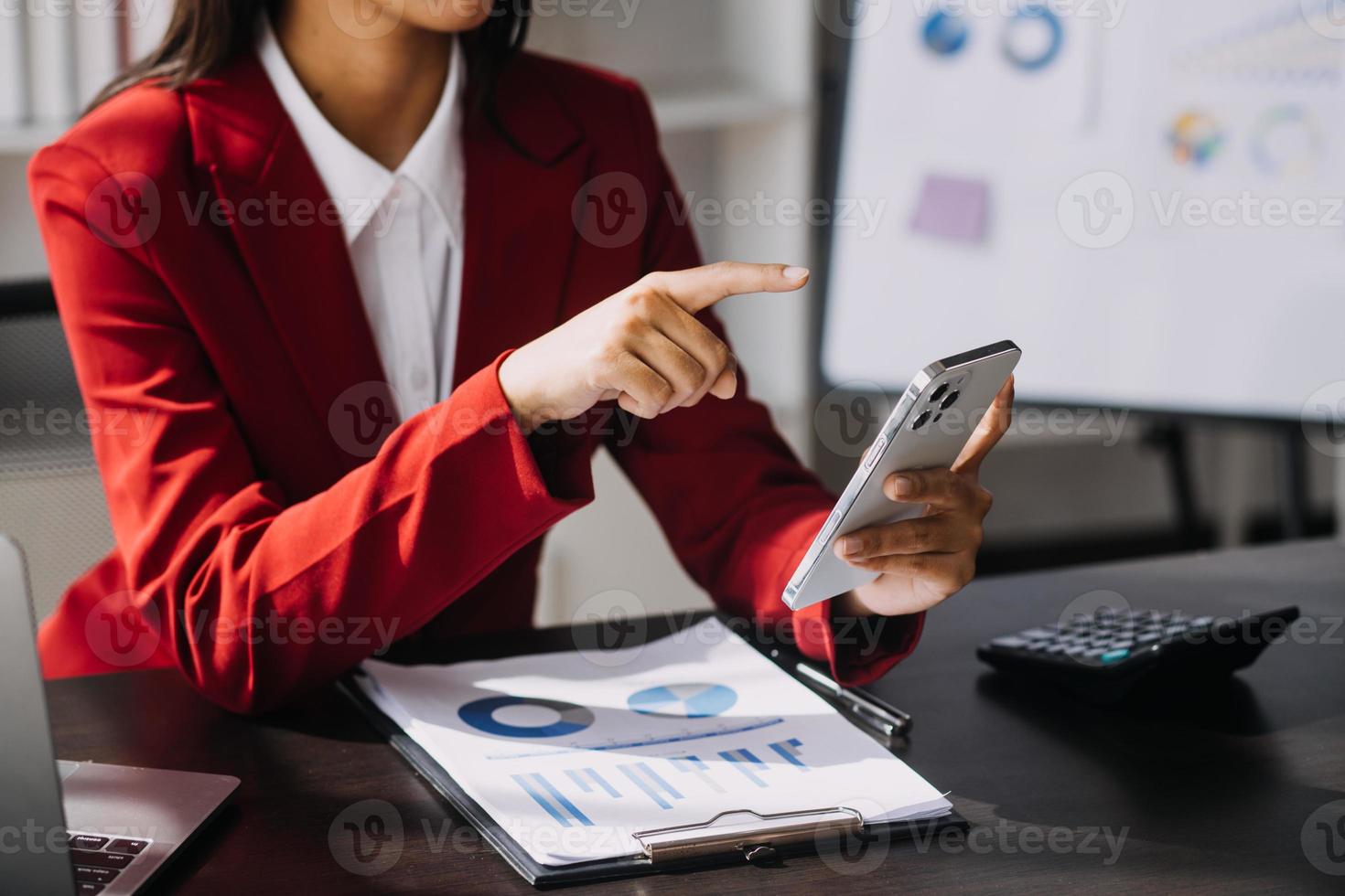 Asian Business woman using calculator and laptop for doing math finance on an office desk, tax, report, accounting, statistics, and analytical research concept photo