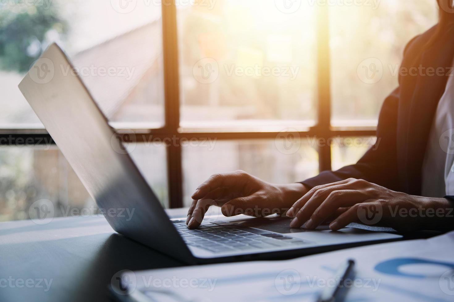 Asian Business woman using calculator and laptop for doing math finance on an office desk, tax, report, accounting, statistics, and analytical research concept photo
