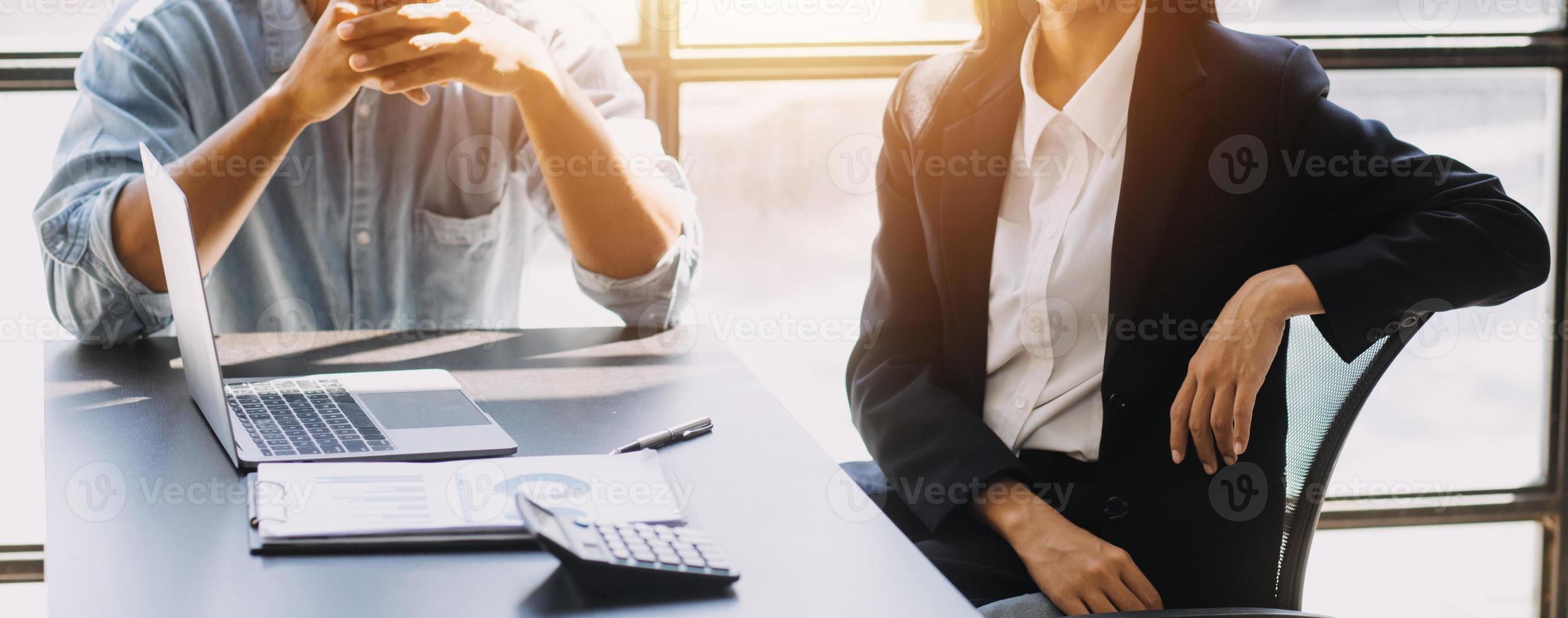 Asian Business woman using calculator and laptop for doing math finance on an office desk, tax, report, accounting, statistics, and analytical research concept photo