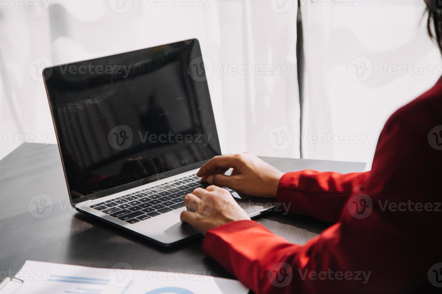 Asian Business woman using calculator and laptop for doing math finance on an office desk, tax, report, accounting, statistics, and analytical research concept photo