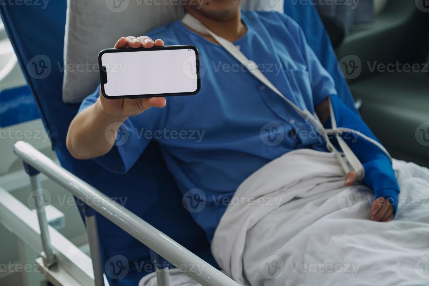 Man with broken arm in cast lying on bed in hospital. The emergency center treatment is plaster and hangs with sling for a further cure in an orthopedic clinic. Patient pain from accident injury. photo