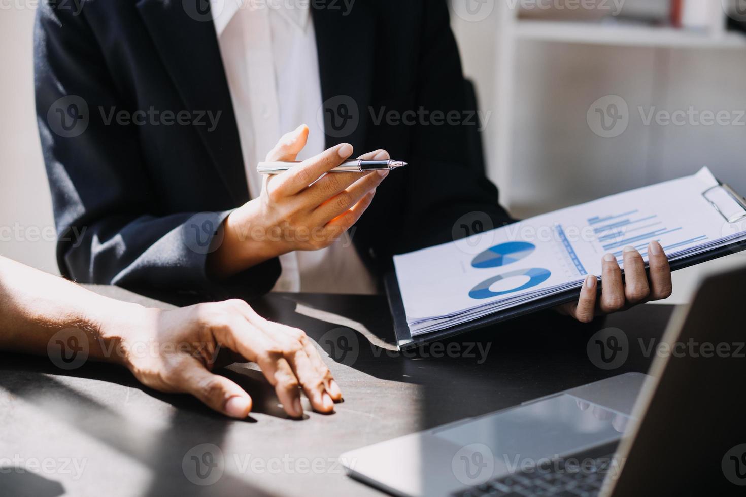 Asian Business woman using calculator and laptop for doing math finance on an office desk, tax, report, accounting, statistics, and analytical research concept photo