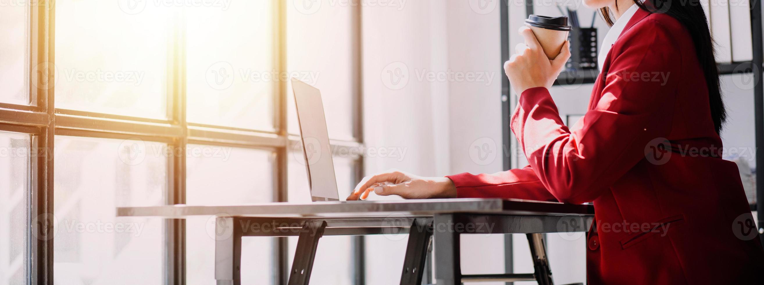 Asian Business woman using calculator and laptop for doing math finance on an office desk, tax, report, accounting, statistics, and analytical research concept photo