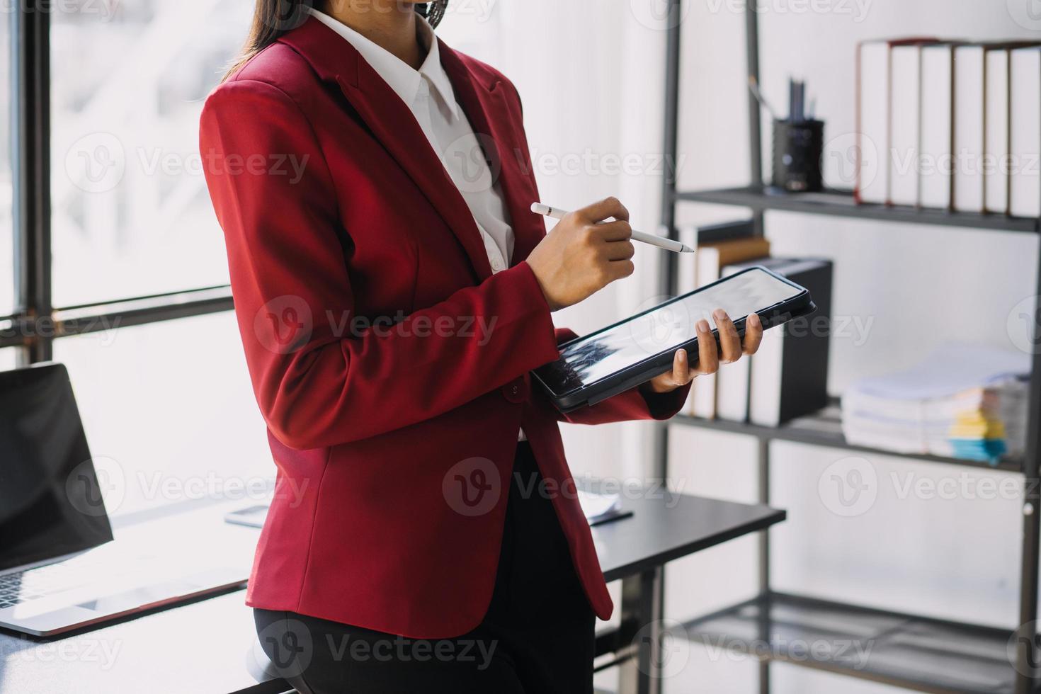 Asian Business woman using calculator and laptop for doing math finance on an office desk, tax, report, accounting, statistics, and analytical research concept photo