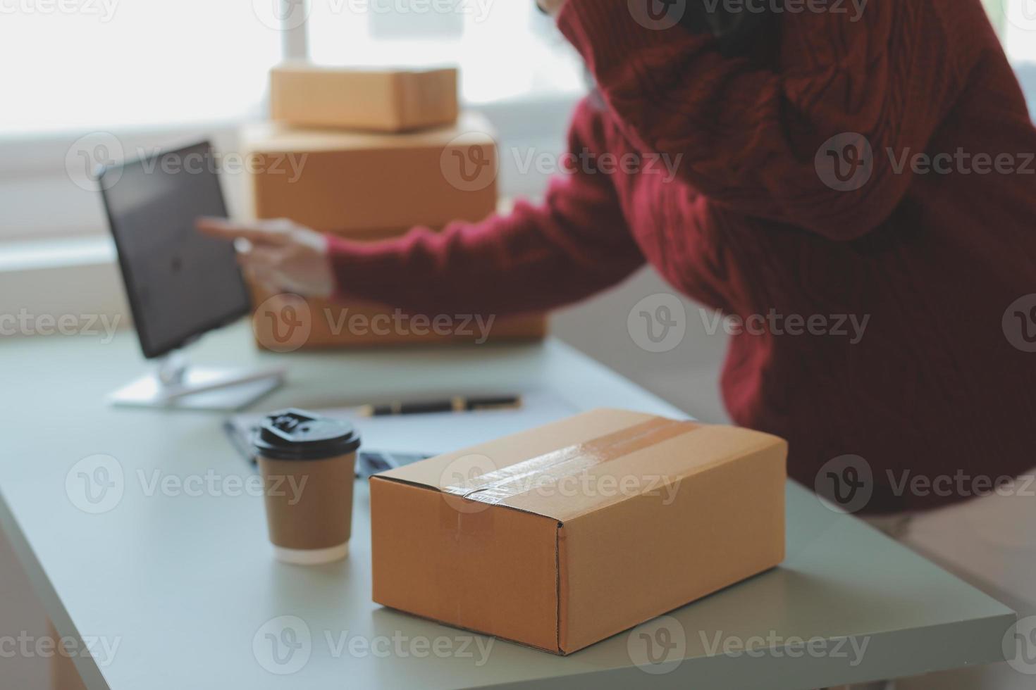 Entrepreneurs Small Business SME Independent men work at home Use smartphones and laptops for commercial checking, online marketing, packing boxes, SME sellers, concept, e-commerce team, online sales photo