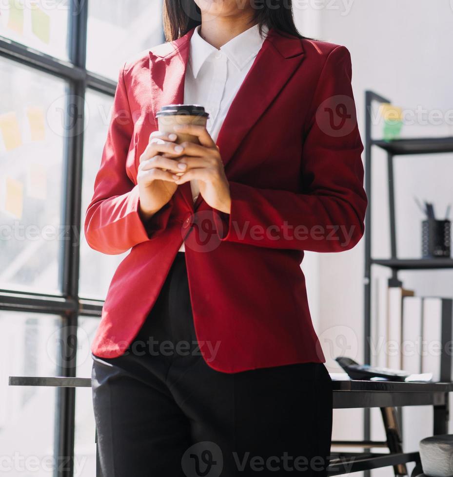 Asian Business woman using calculator and laptop for doing math finance on an office desk, tax, report, accounting, statistics, and analytical research concept photo